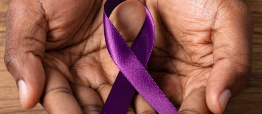 Hands holding a purple ribbon for Alzheimer’s and Brain Awareness Month