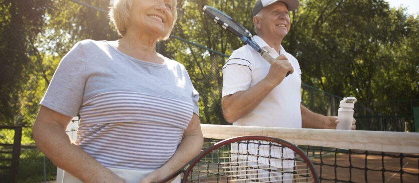 two friends stand on either side of a tennis court