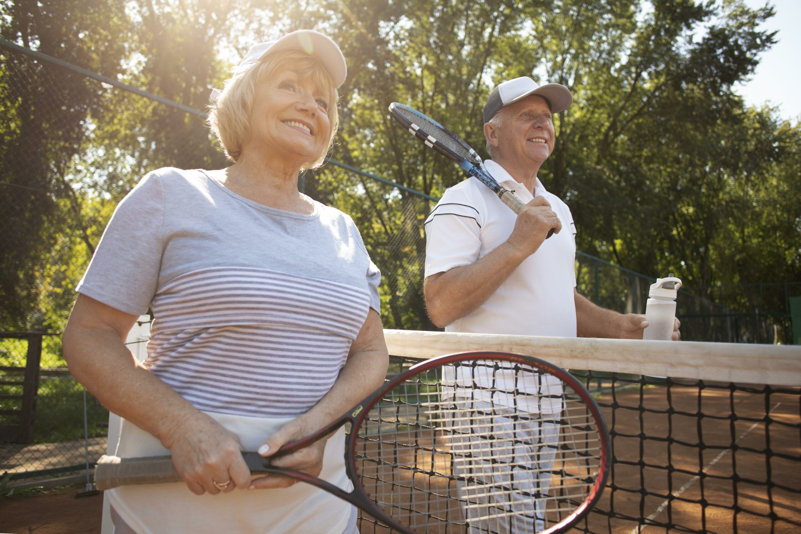 two friends stand on either side of a tennis court